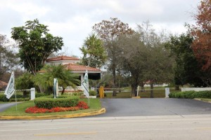 A gated entrance to a residential area with trees.