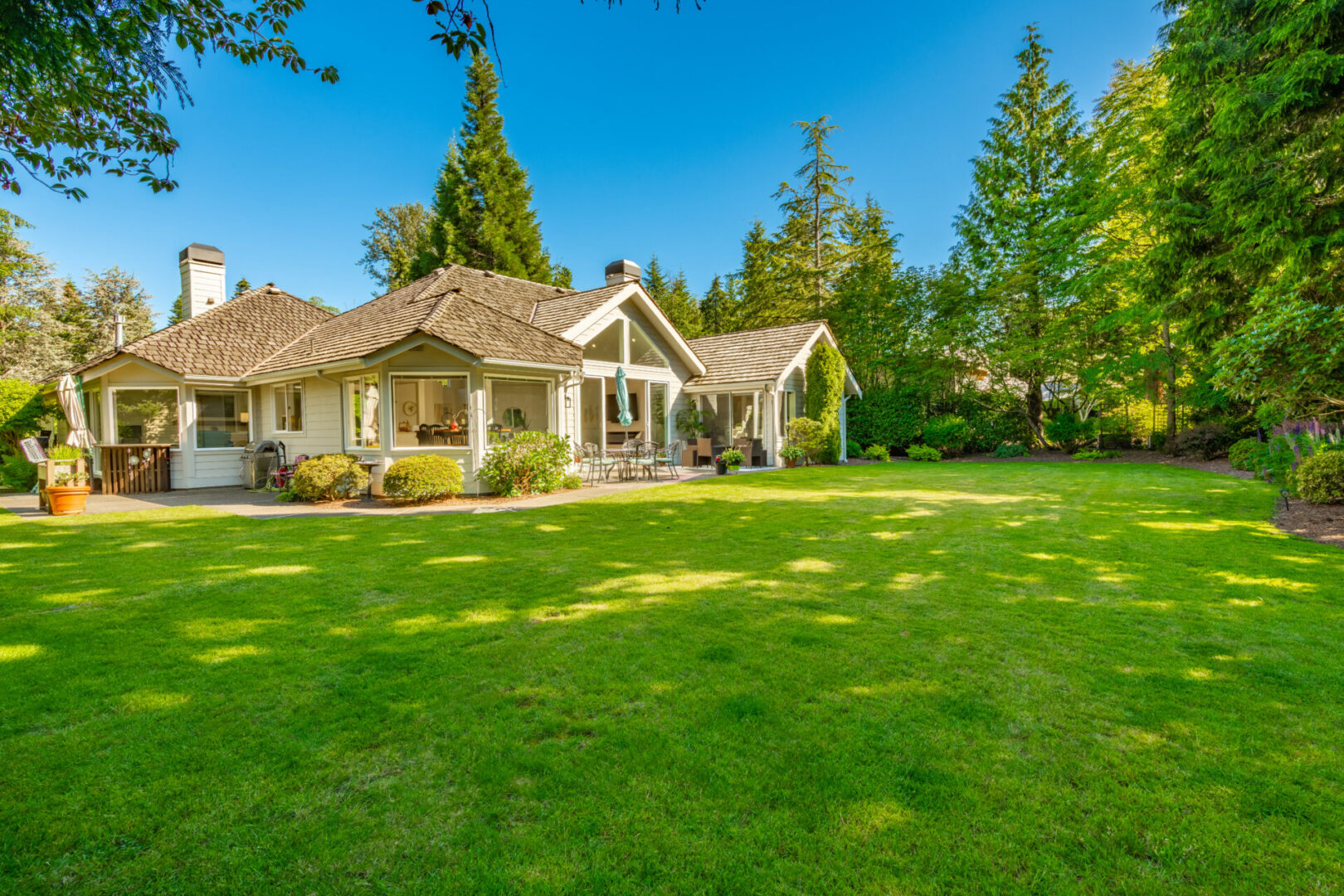 House with spacious green lawn and trees.